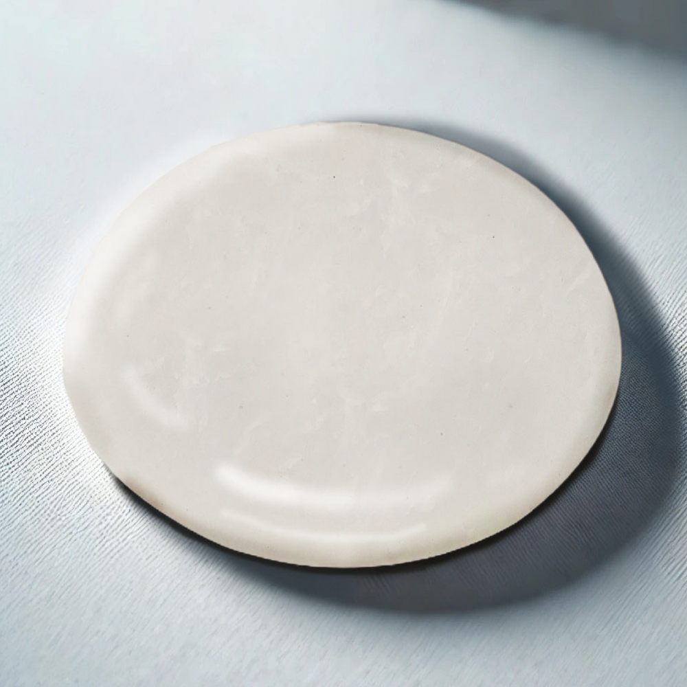 Round piece of white marble on a light gray surface